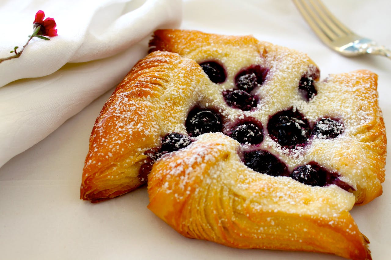 Delicious homemade berry Danish pastry with powdered sugar on a plate.