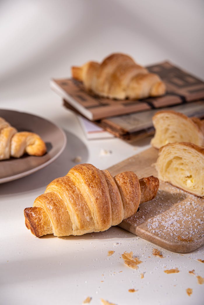 Crispy golden croissants on a plate and board, perfect for breakfast or snack.