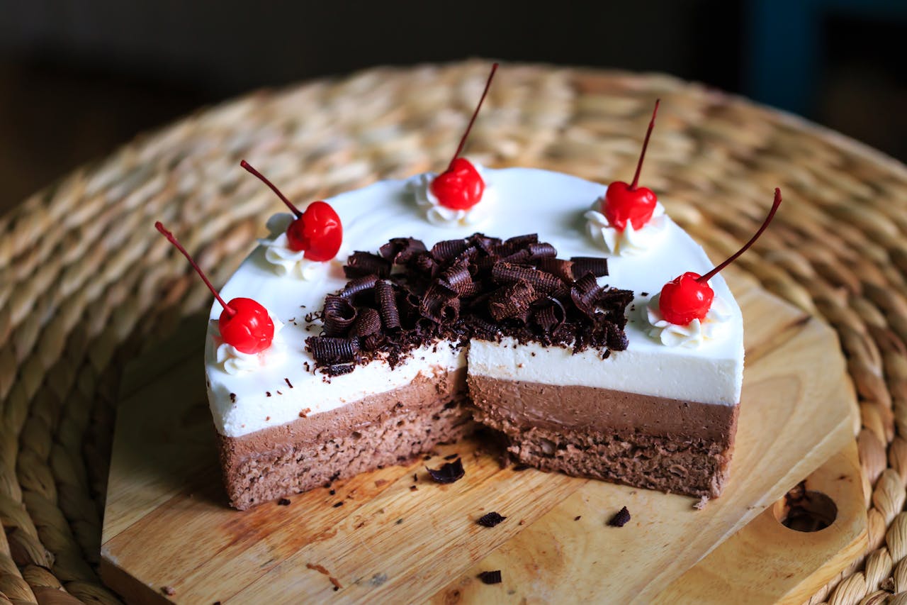 Delicious chocolate mousse cake topped with cream, cherries, and chocolate shavings.