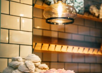 Charming display of pink and white Italian meringues in a cozy bakery setting.